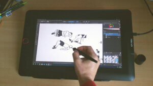 Infographiste en train de dessiner sur une tablette graphique des pictogrammes d'éducation thérapeutique pour les patients de kinés